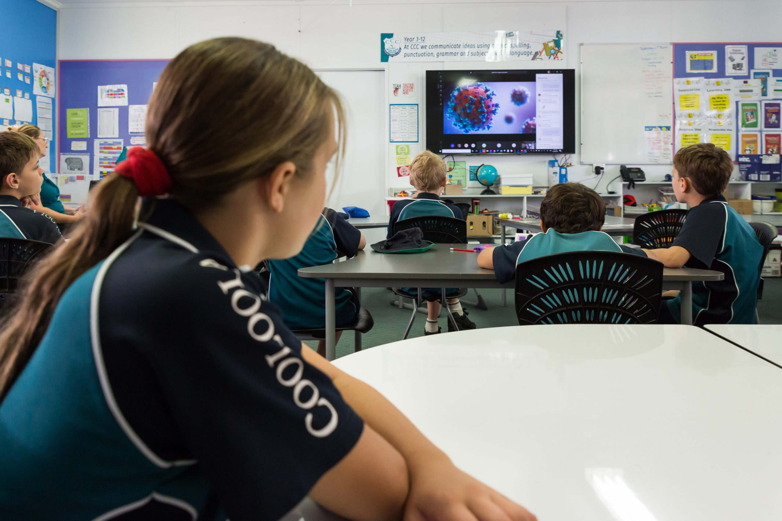 Students in a classroom looking at a classroom display mounted at the front of the class.
