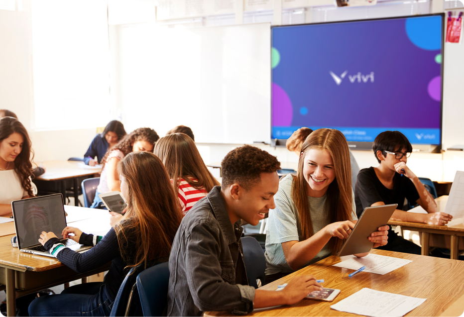 Students in a classroom. A screen can be seen with Vivi in the background.