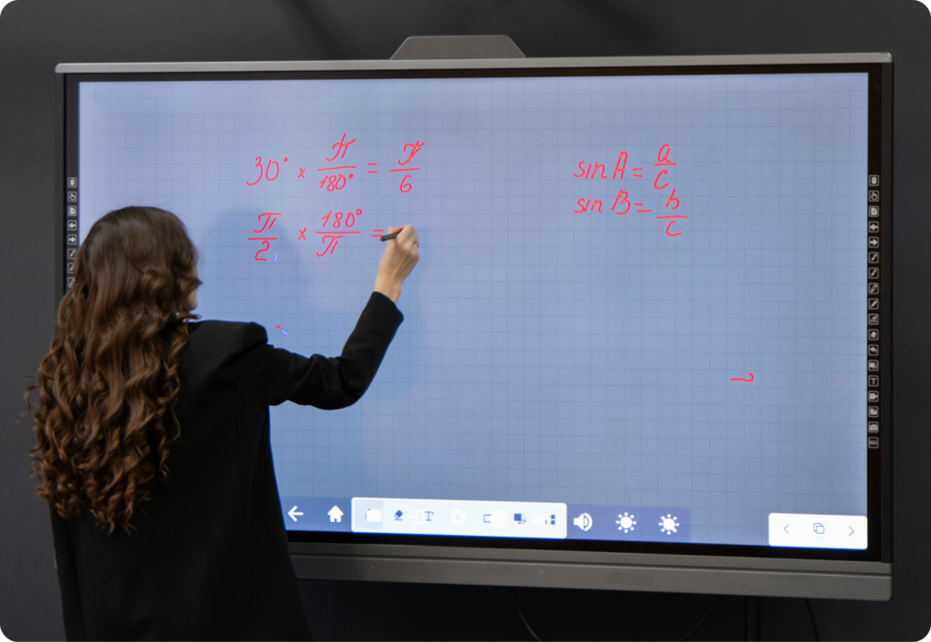 Upgrade Smarter: Is Your School Ready for IFP Alternatives? 2 Teacher tethered to the front of the classroom using an IFP, emphasizing a conventional approach.
