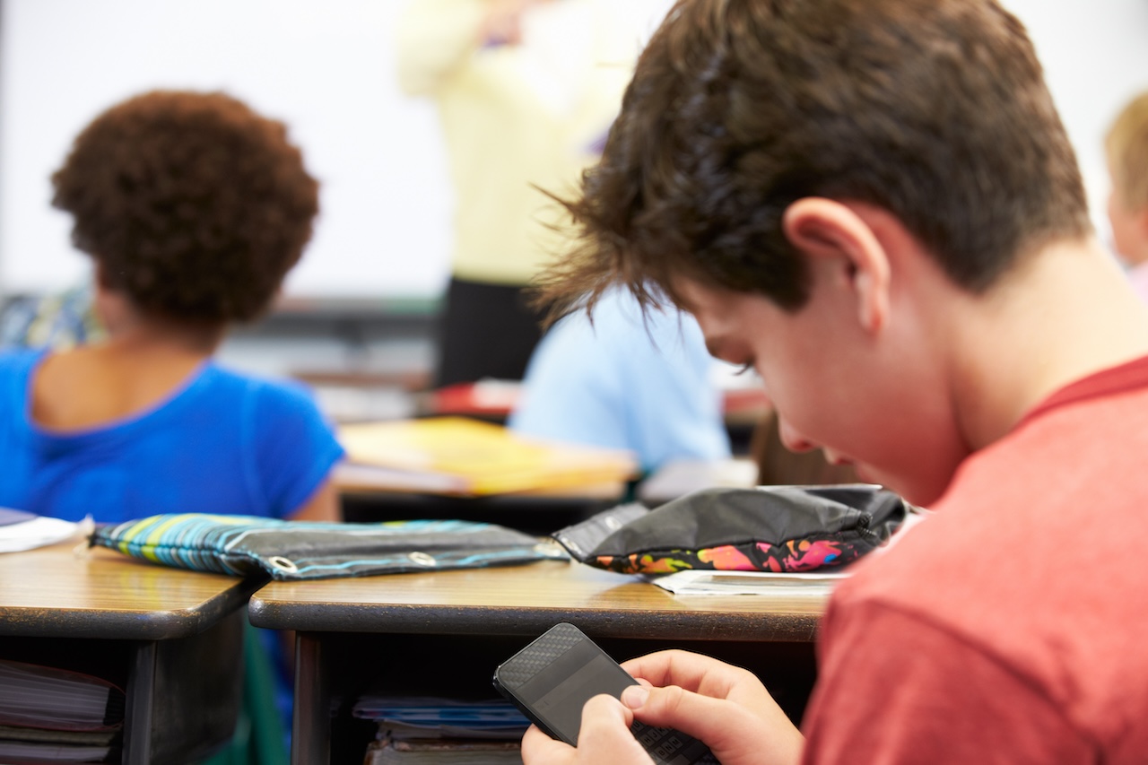 School-Wide Support for Cell Phone Policies: How Vivi Can Help 1 a boy using a cell phone