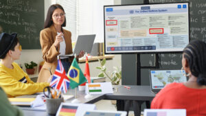 A teacher standing by international flags.